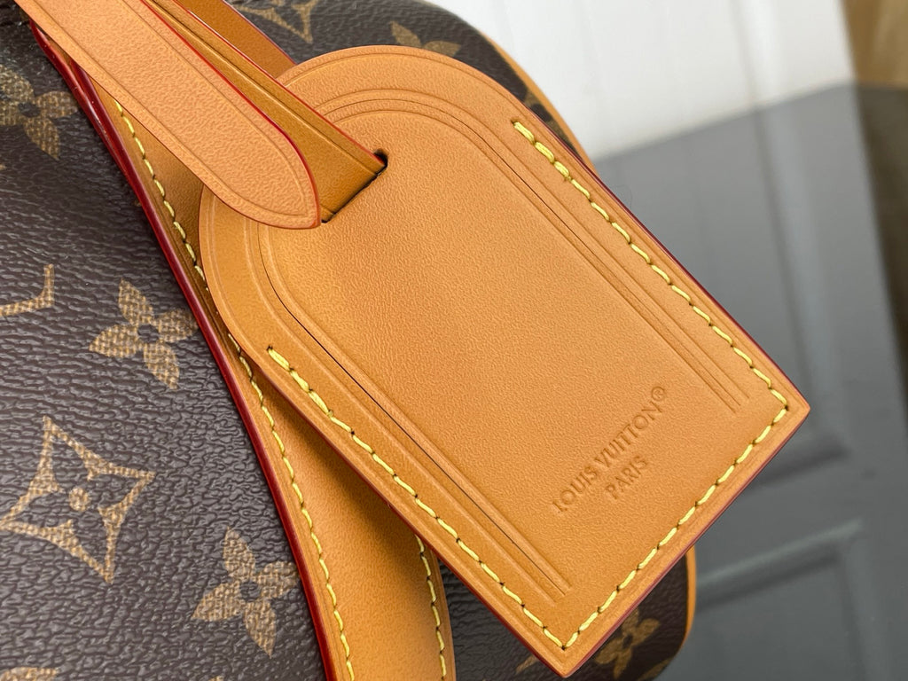 Tan leather luggage tag with embossed Louis Vuitton logo on monogram canvas