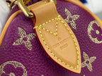 Louis Vuitton purple monogram handbag close-up of tan strap attachment and stitched tab
