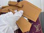 Louis Vuitton purple monogram handbag close-up with tan leather tab and stitched edge