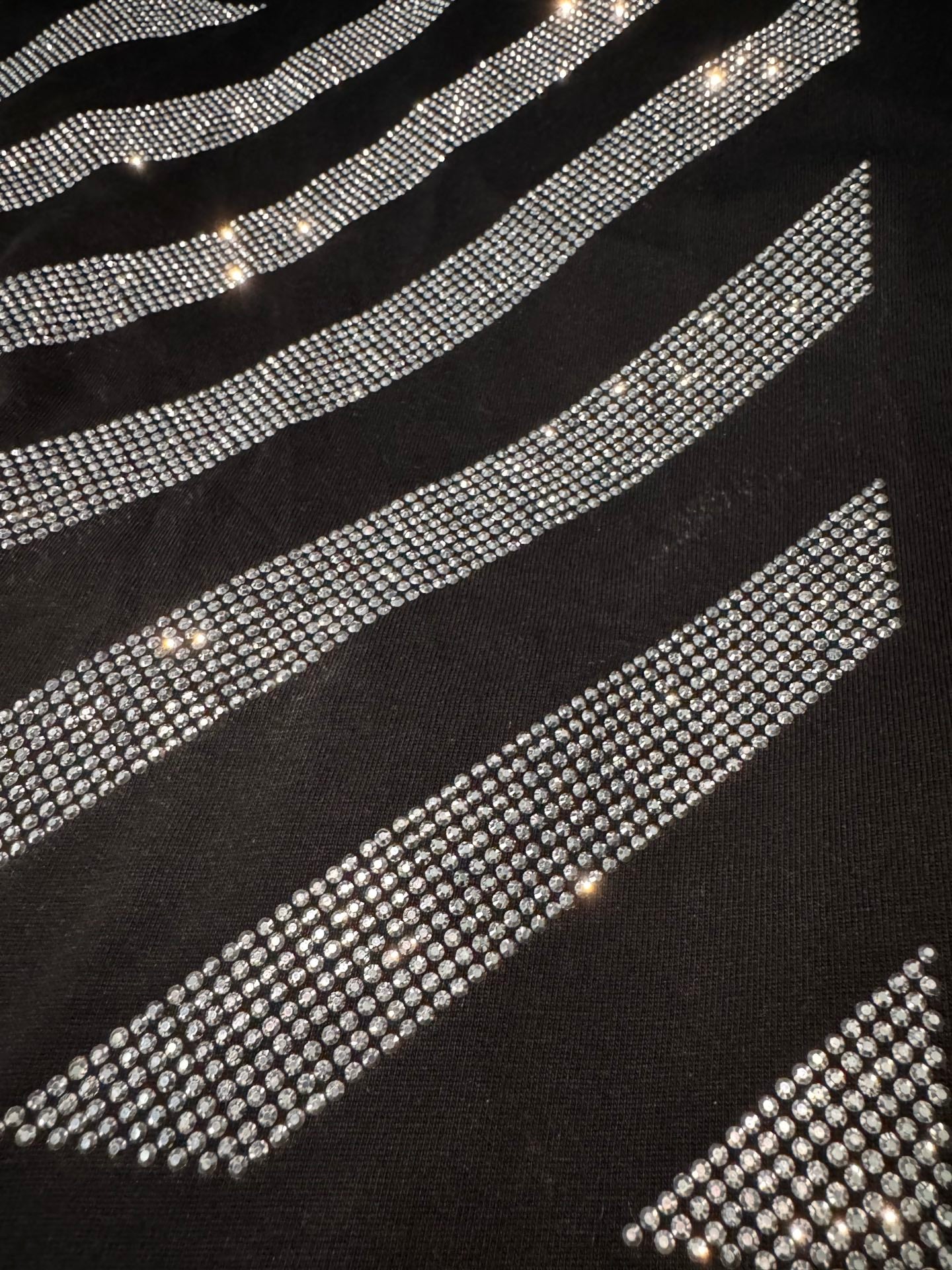 Black T-shirt close-up of rhinestone slanted stripe details