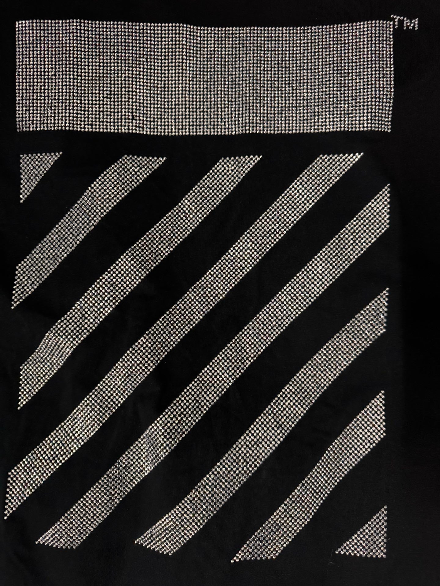 Black T-shirt close-up of rhinestone rectangle and diagonal stripe graphic