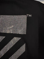 Black T-shirt with rhinestone panel and small logo text near neckline