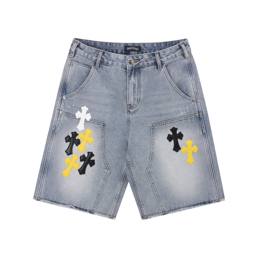 Light-wash denim shorts with embroidered cross patches in black and yellow