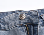Light-wash denim shorts with circular logo button and waistband details