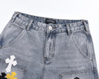 Light-wash denim shorts, front view, with printed cross patches and button fly