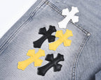 Light-wash denim shorts with close-up cross patches in white, black, and yellow