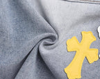 Light-wash denim fabric with yellow cross patch appliqué