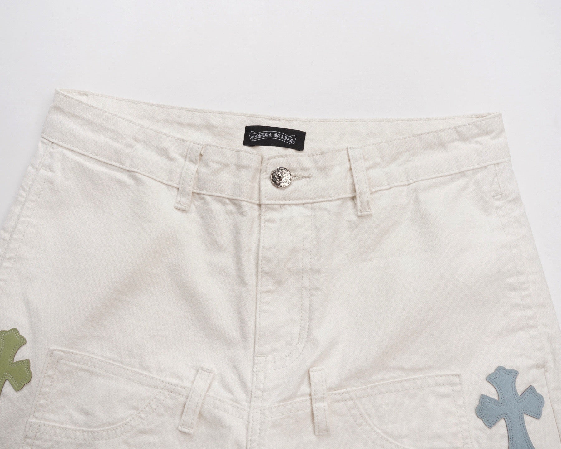 White shorts with logo patch at waistband and multicolor cross details