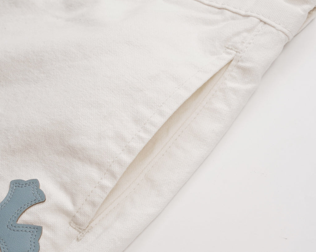 White shorts with stitched side seam and partial cross patch detail