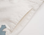 White shorts with stitched side seam and partial cross patch detail