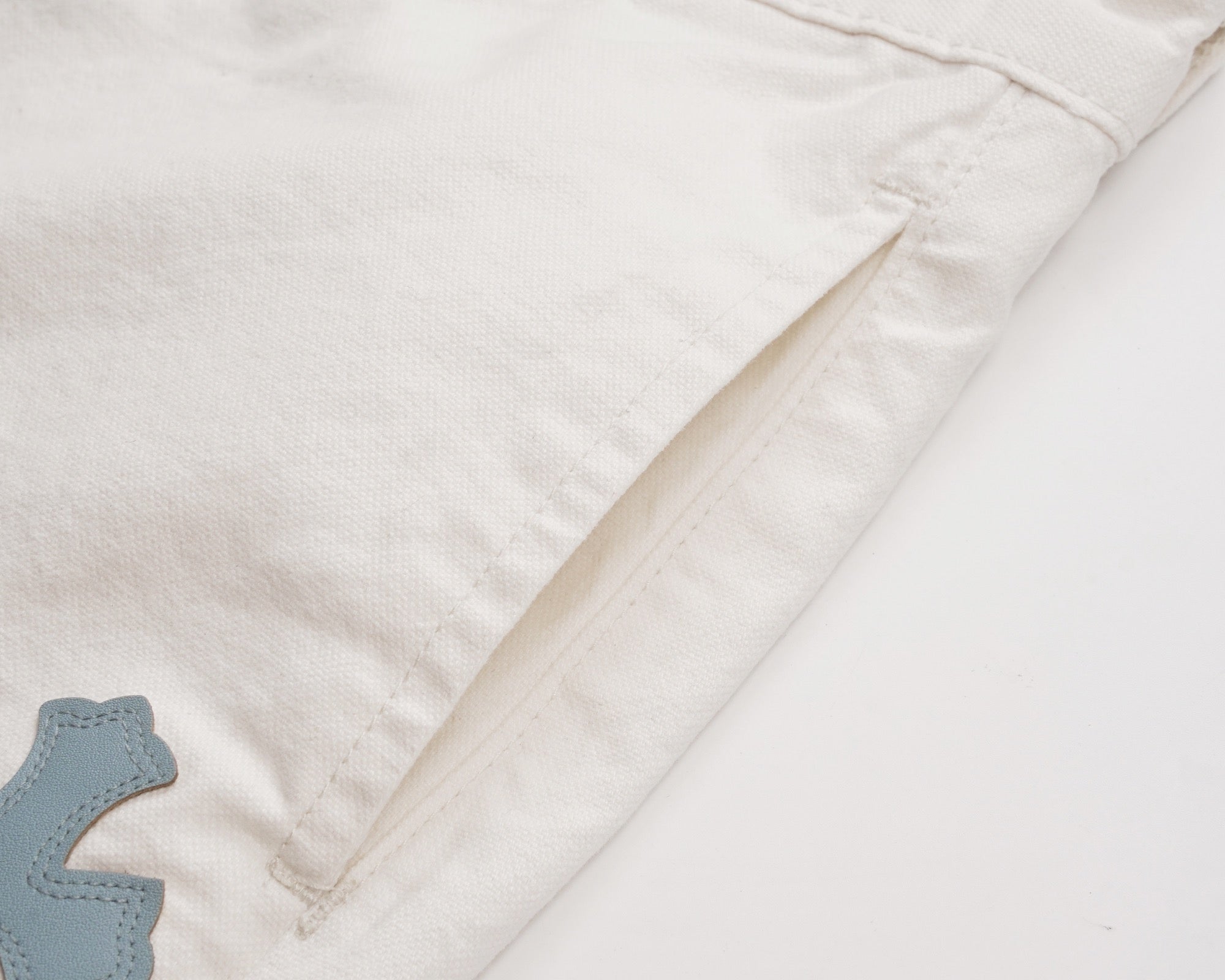 White shorts with stitched side seam and partial cross patch detail