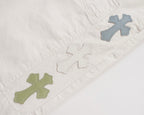 White shorts with green and blue cross patches on the front leg