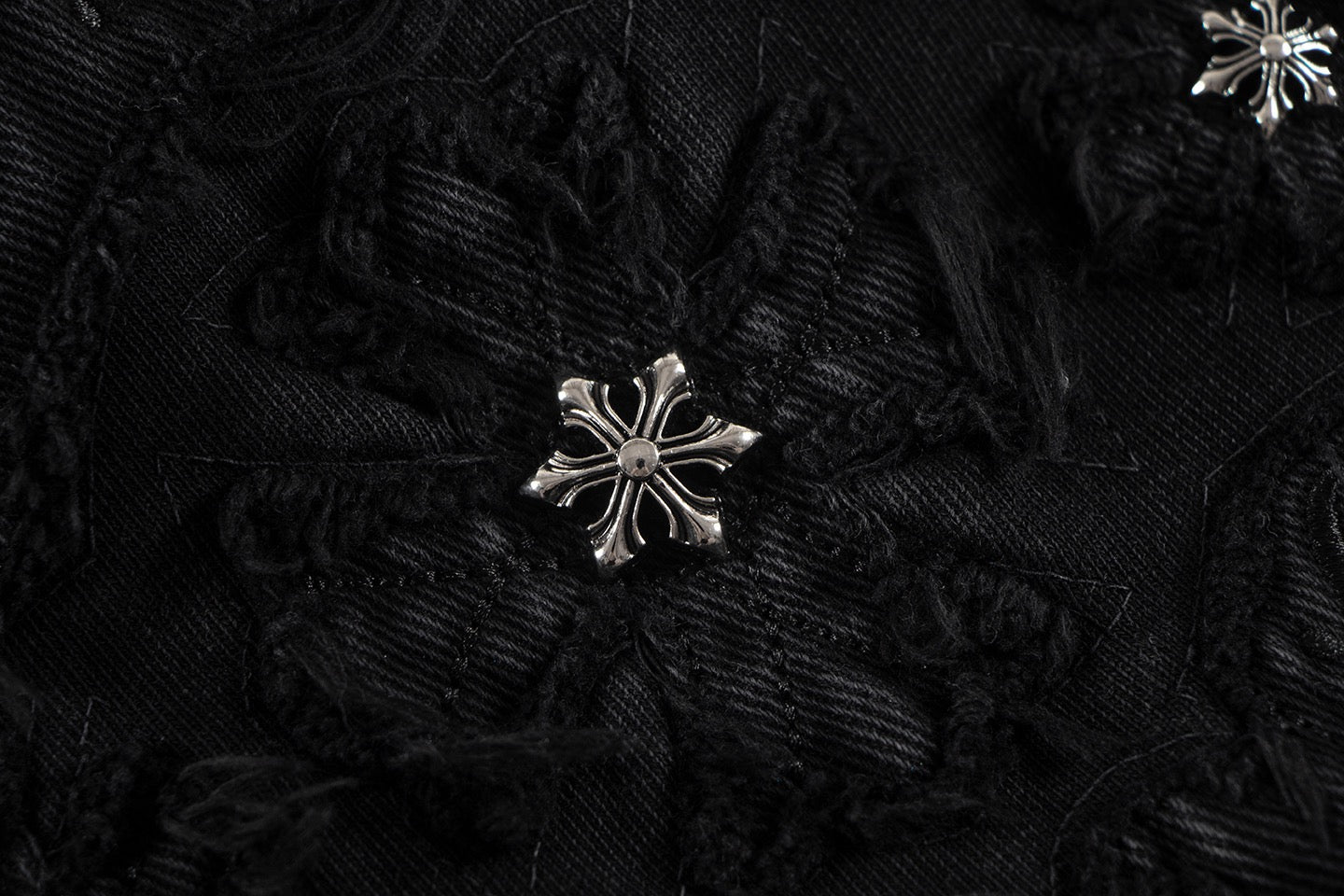Embroidered black fabric patch with silver starburst detail