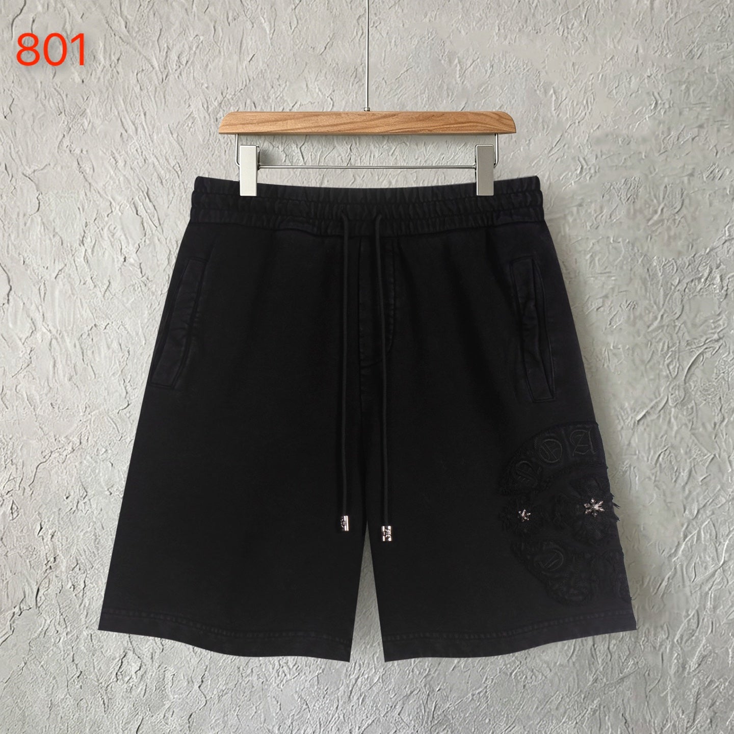 Black shorts with elastic waistband and embroidered side patches