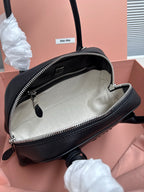 Black leather handbag open view with beige fabric interior and zippered top closure.