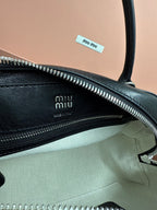 Black leather MiuMiu bag with zipper track and fabric lining, interior logo