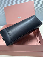 Dark green leather baguette bag with structured rounded silhouette and short handles.