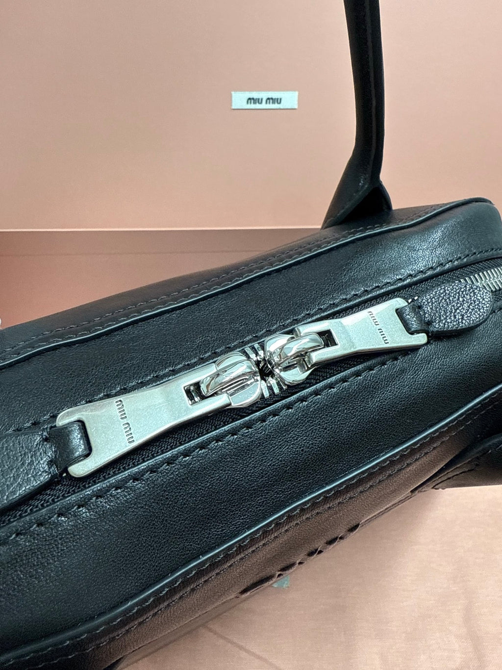 Dark green leather bag with silver buckle detail on top handle strap.