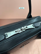 Dark green leather bag with silver buckle detail on top handle strap.