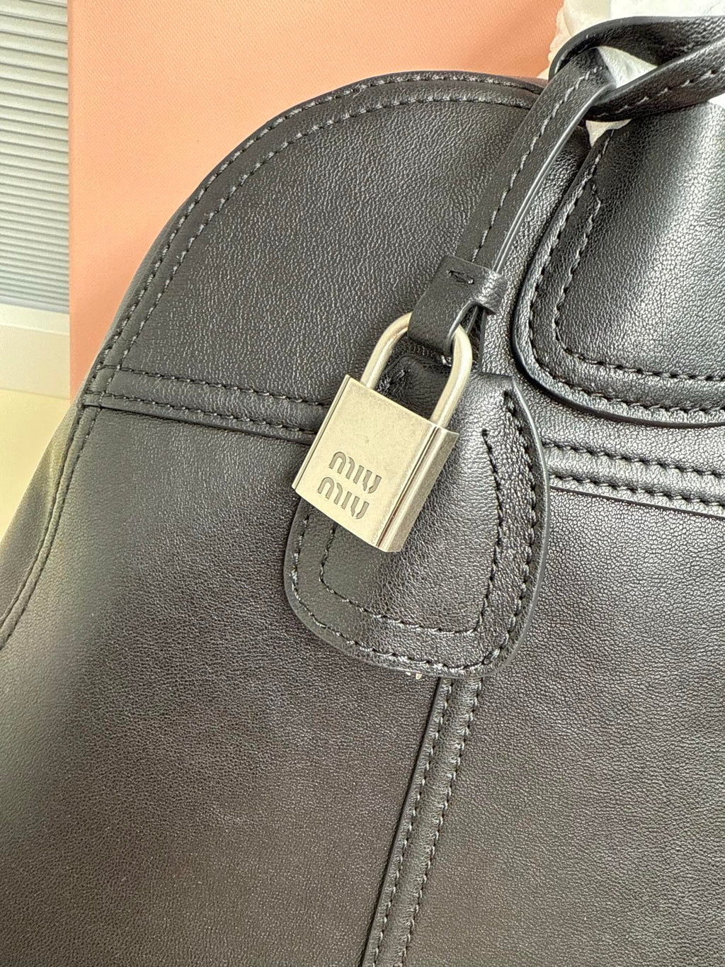 MiuMiu leather handbag top corner with buckle detail and stitched pocket