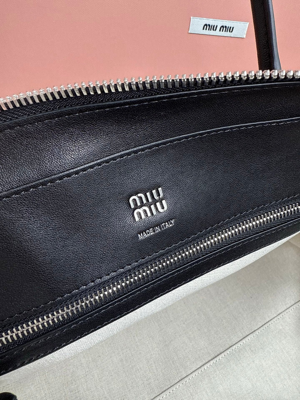MiuMiu leather handbag close-up of front zipper with Miu Miu branding
