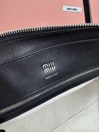 MiuMiu leather handbag close-up of front zipper with Miu Miu branding