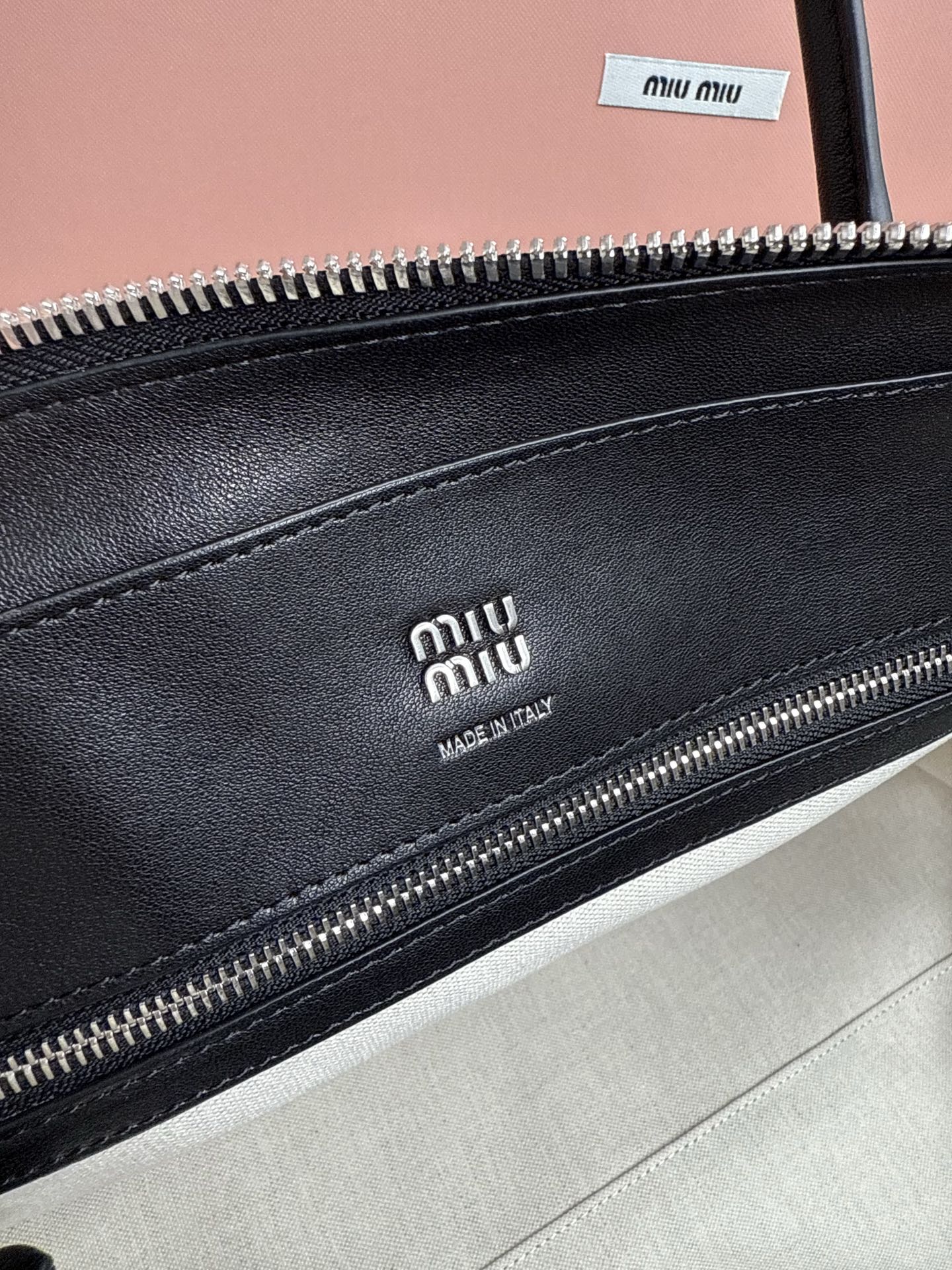 MiuMiu leather handbag close-up of front zipper with Miu Miu branding