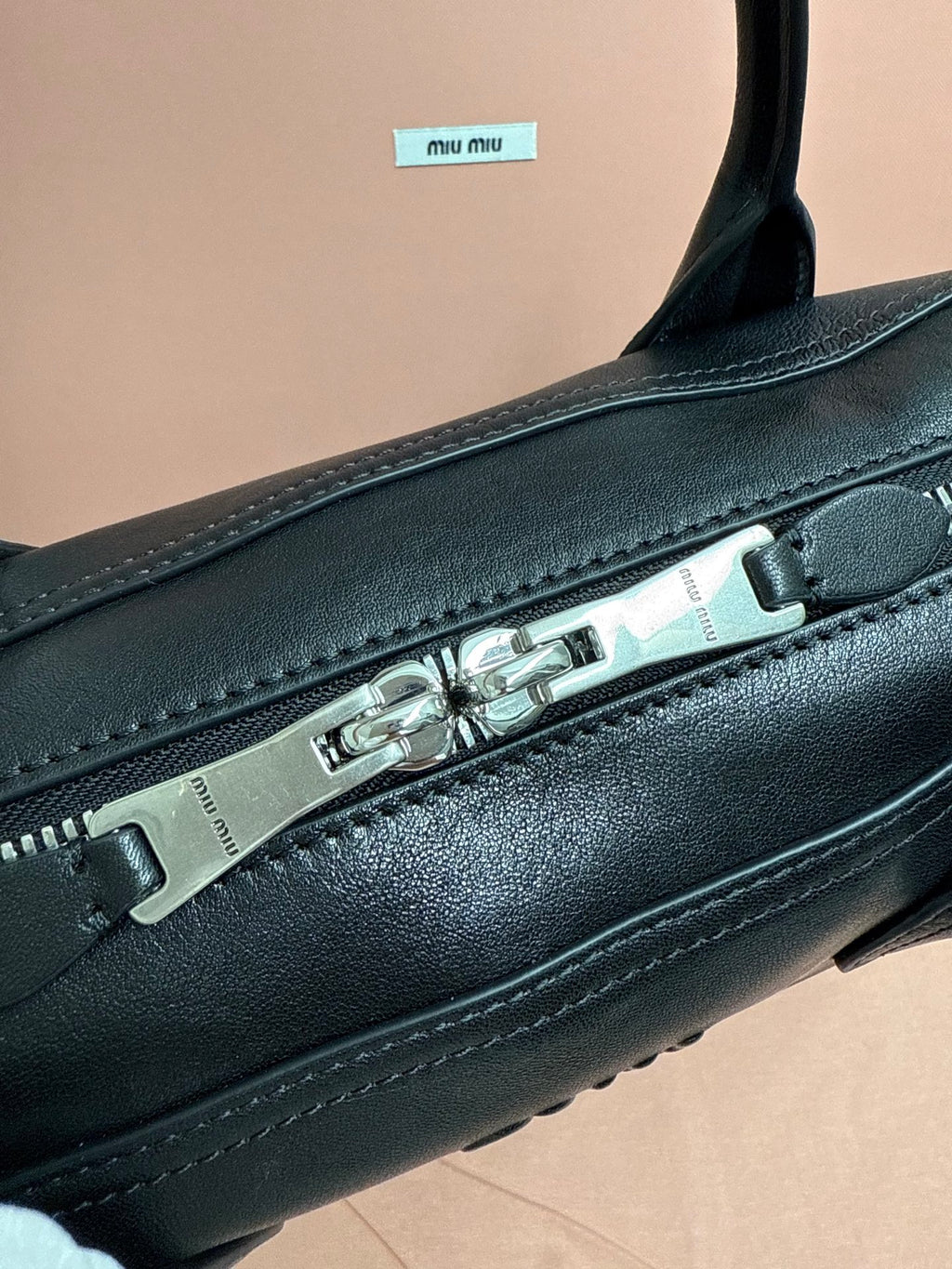MiuMiu leather handbag close-up of metal zipper and top trim stitching