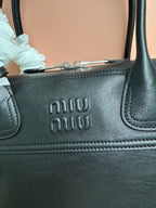 MiuMiu leather handbag close-up of embossed logo on front panel