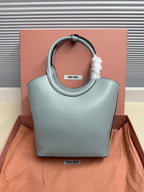 Miu Miu mini tote bag in light teal leather with top handle and small logo patch.