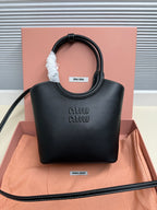 Black leather Miu Miu handbag with curved top handles and embossed logo on front.