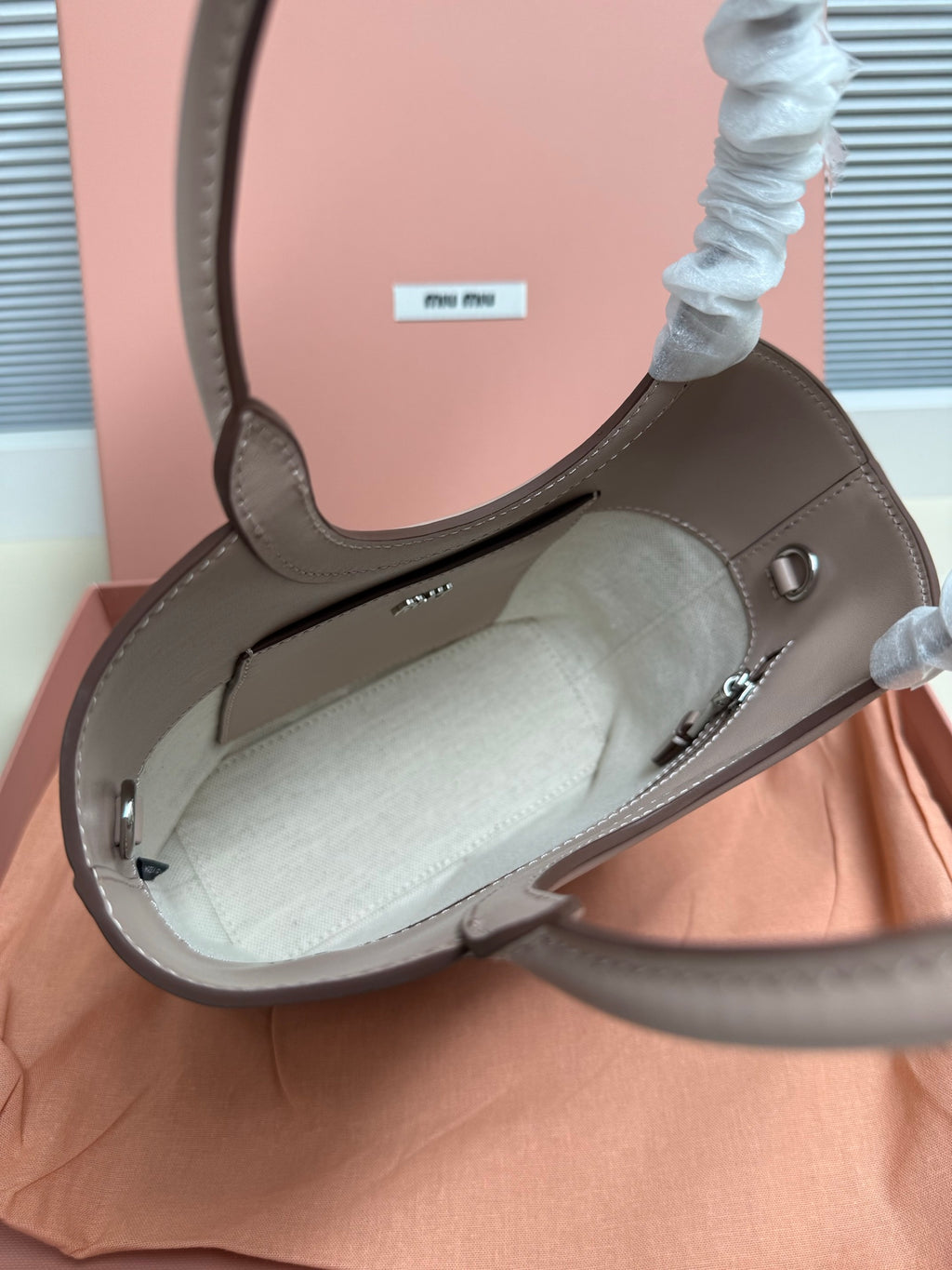MiuMiu mini tote bag open view in light gray leather with metal clasp hardware