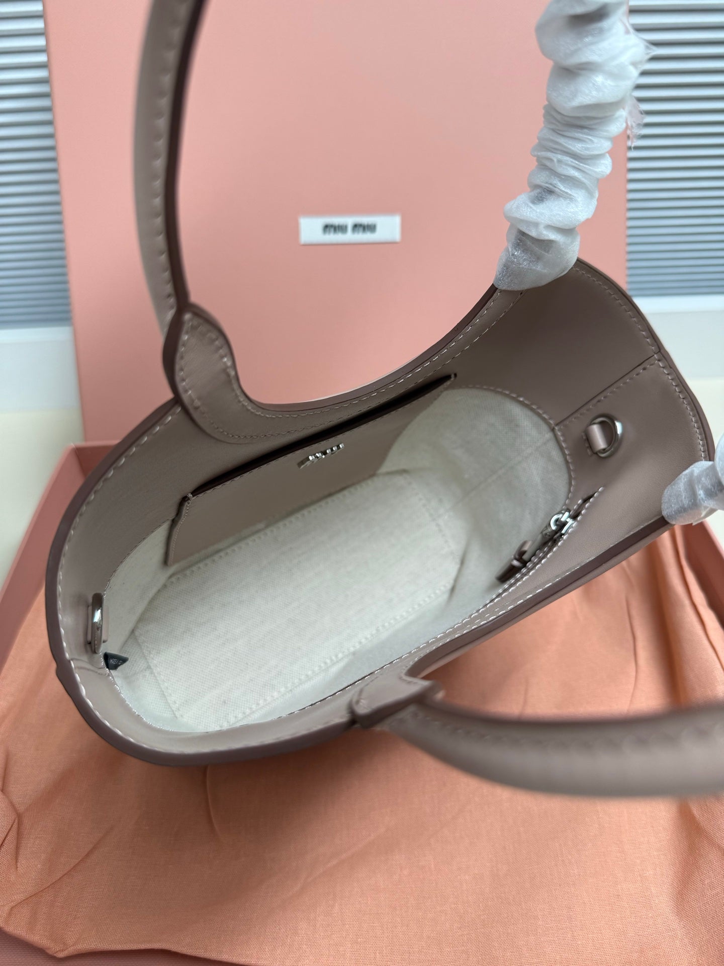 MiuMiu mini tote bag open view in light gray leather with metal clasp hardware