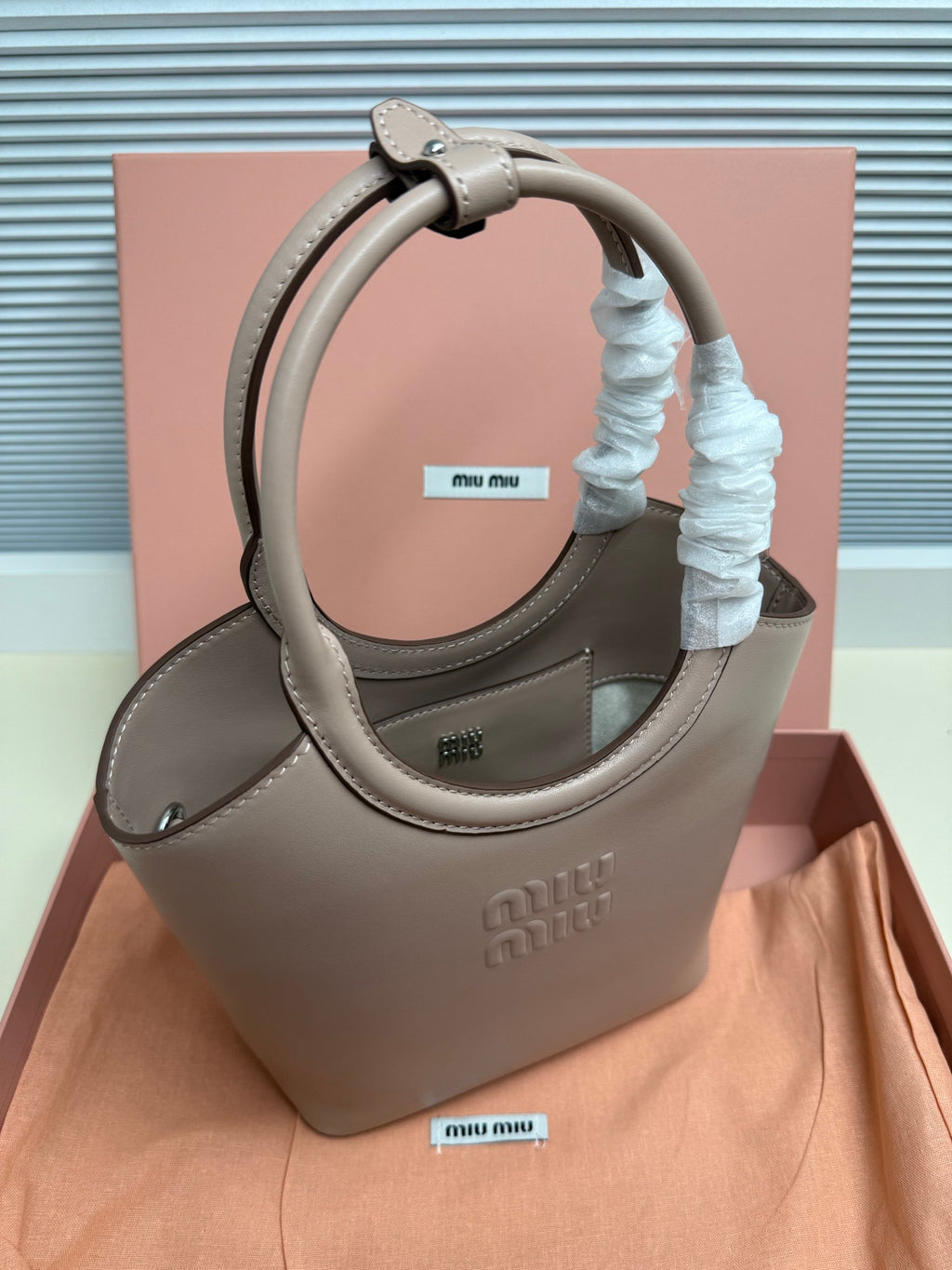MiuMiu mini bag with structured shape in light gray leather, long strap and blue scrunchie