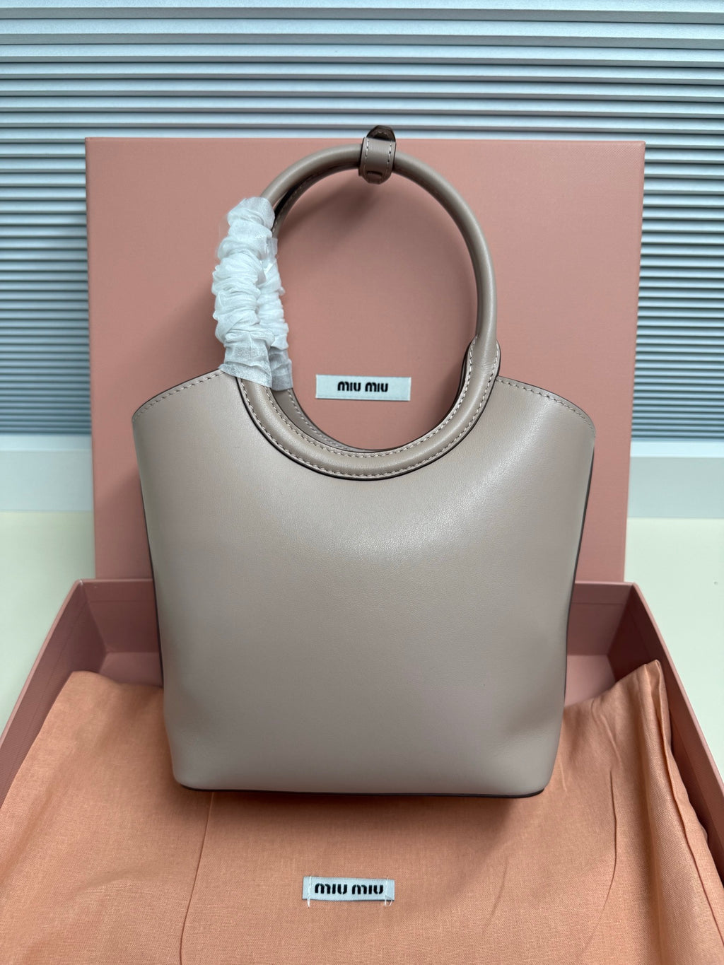 MiuMiu mini tote bag, light gray leather, rounded handles with blue scrunchie