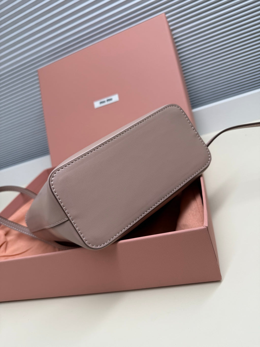MiuMiu crossbody bag with flap in light gray leather, shown in box