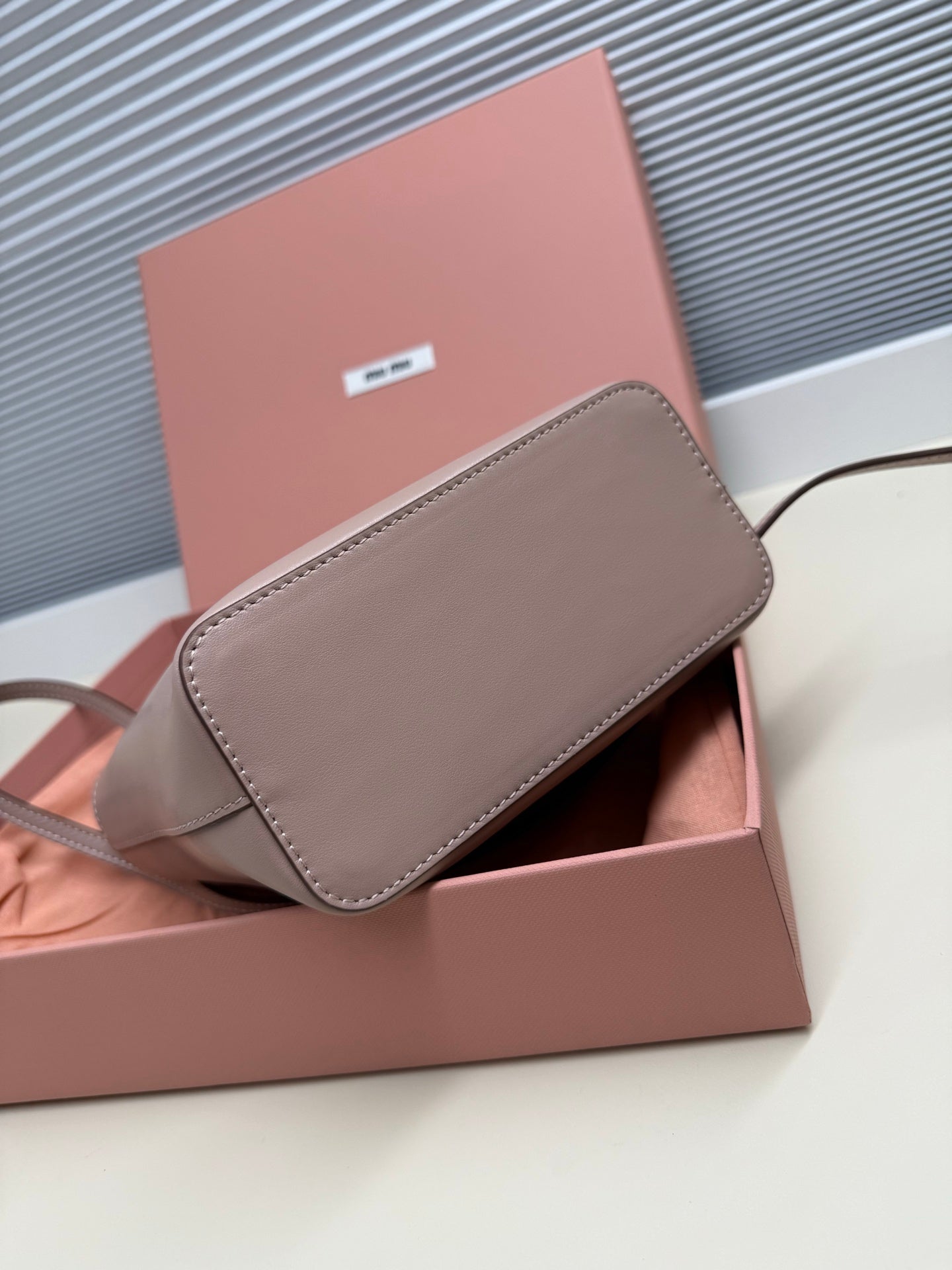 MiuMiu crossbody bag with flap in light gray leather, shown in box