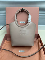 MiuMiu mini tote bag in light gray with top handles and embossed logo