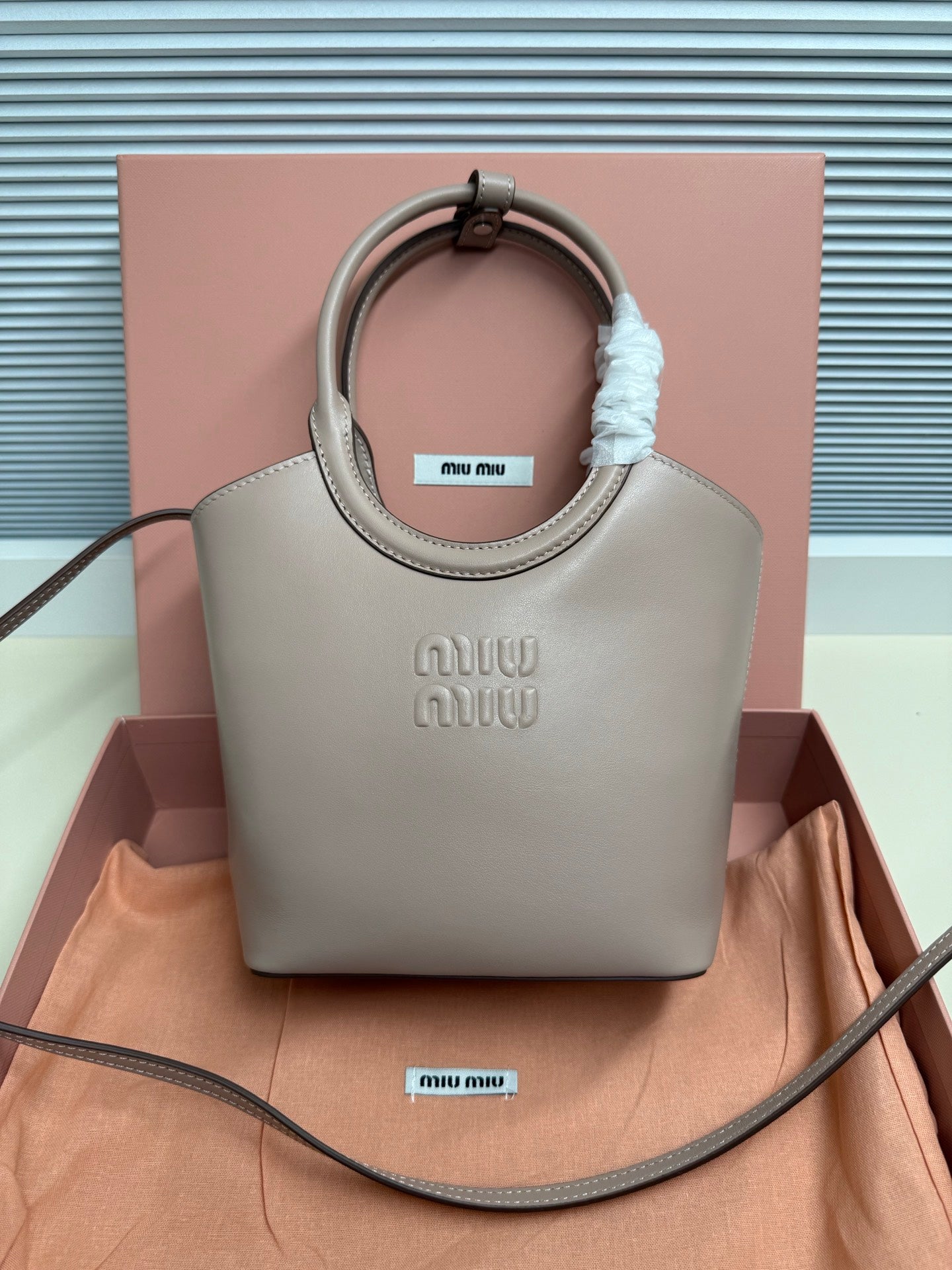 MiuMiu mini tote bag in light gray with top handles and embossed logo