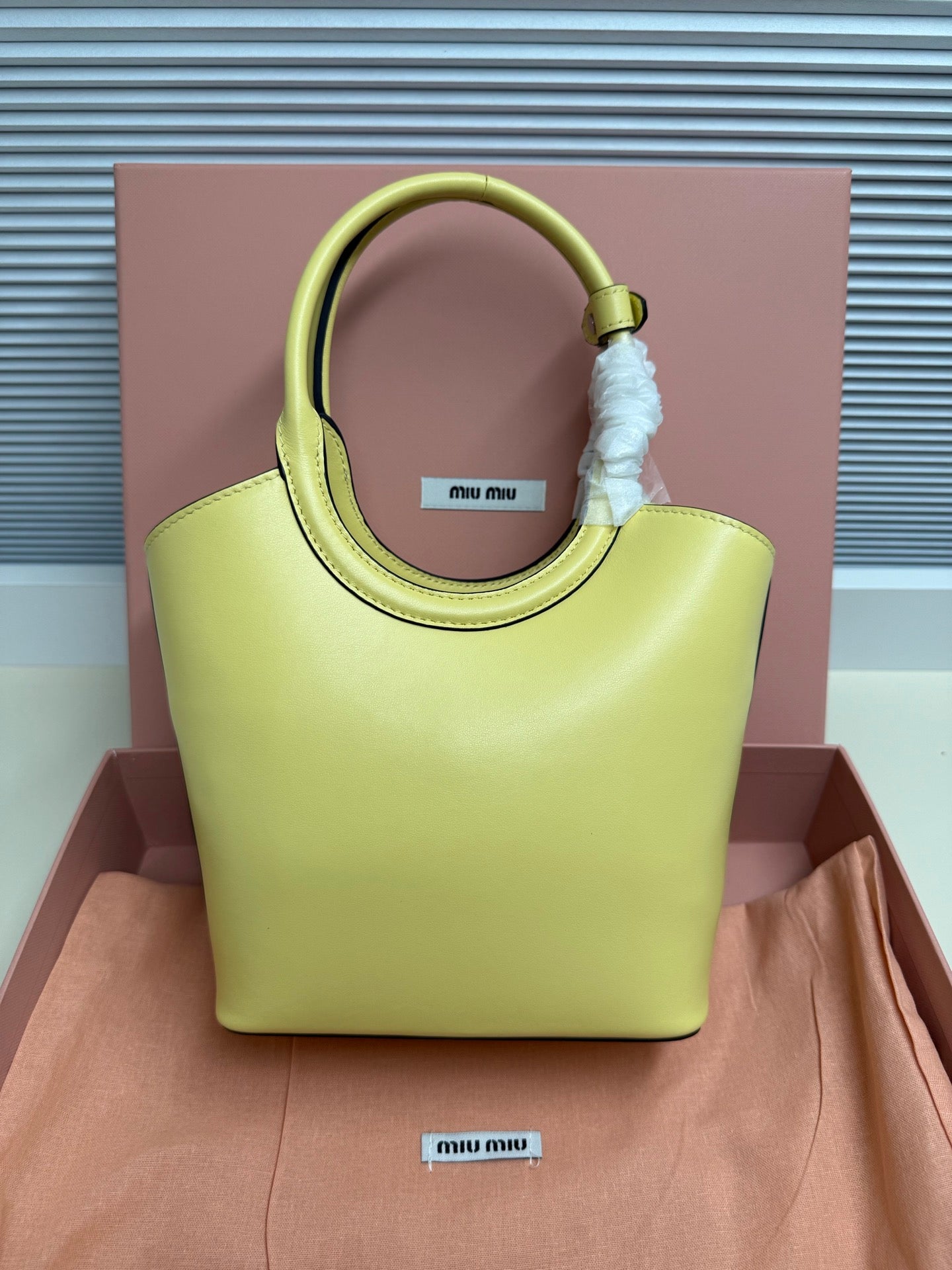 Lime green MiuMiu tote bag with top handle and embossed logo on front