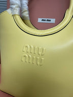 Lime green MiuMiu tote bag close-up of embossed front logo