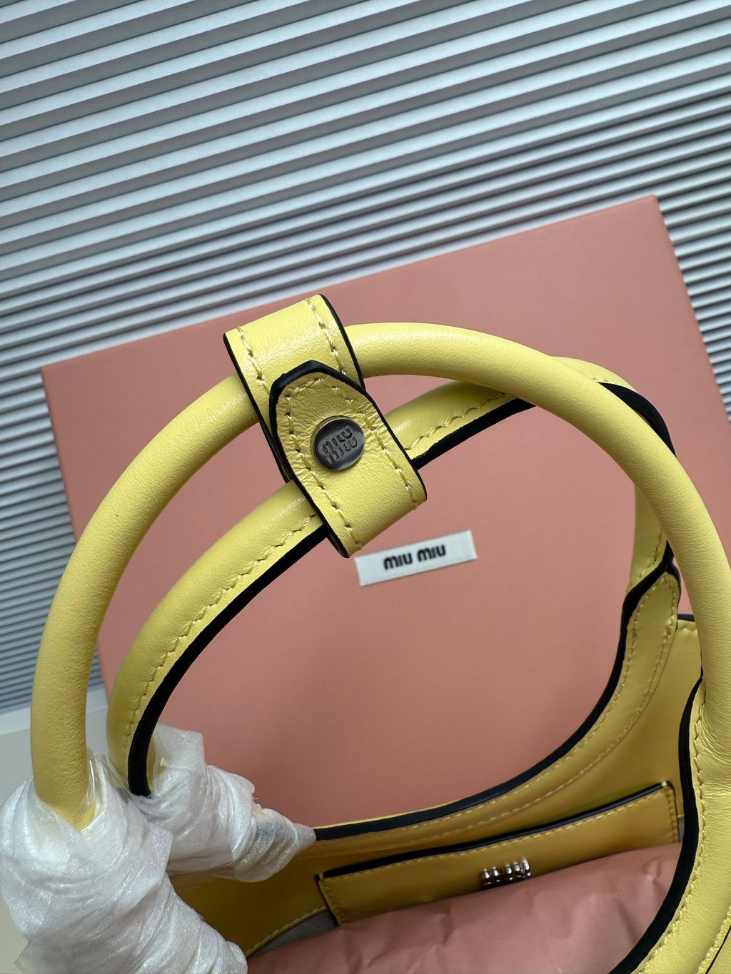 Lime green MiuMiu tote bag close-up of handle strap and hardware detail