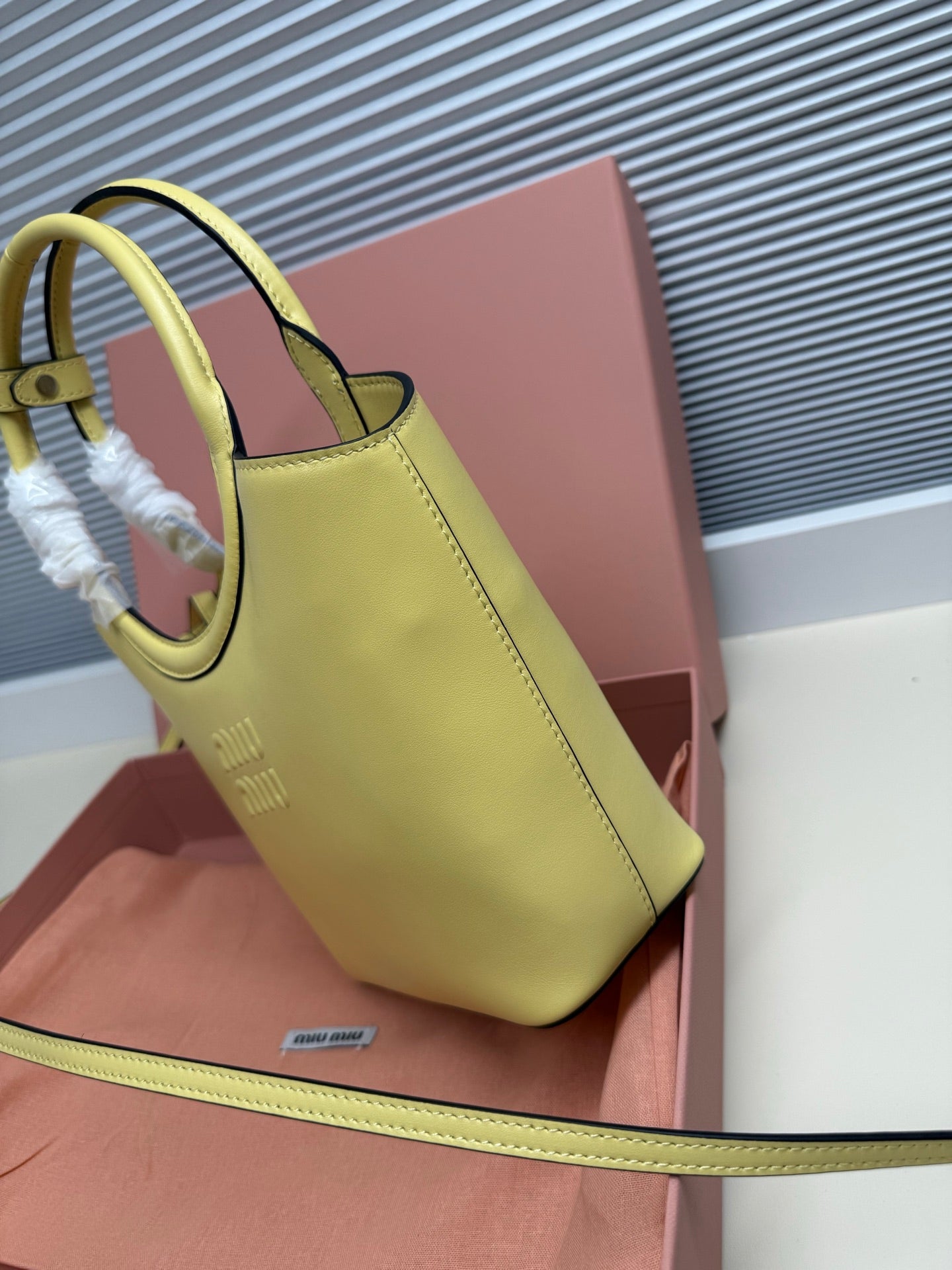 Lime green MiuMiu tote bag side view with top handle and contrast piping