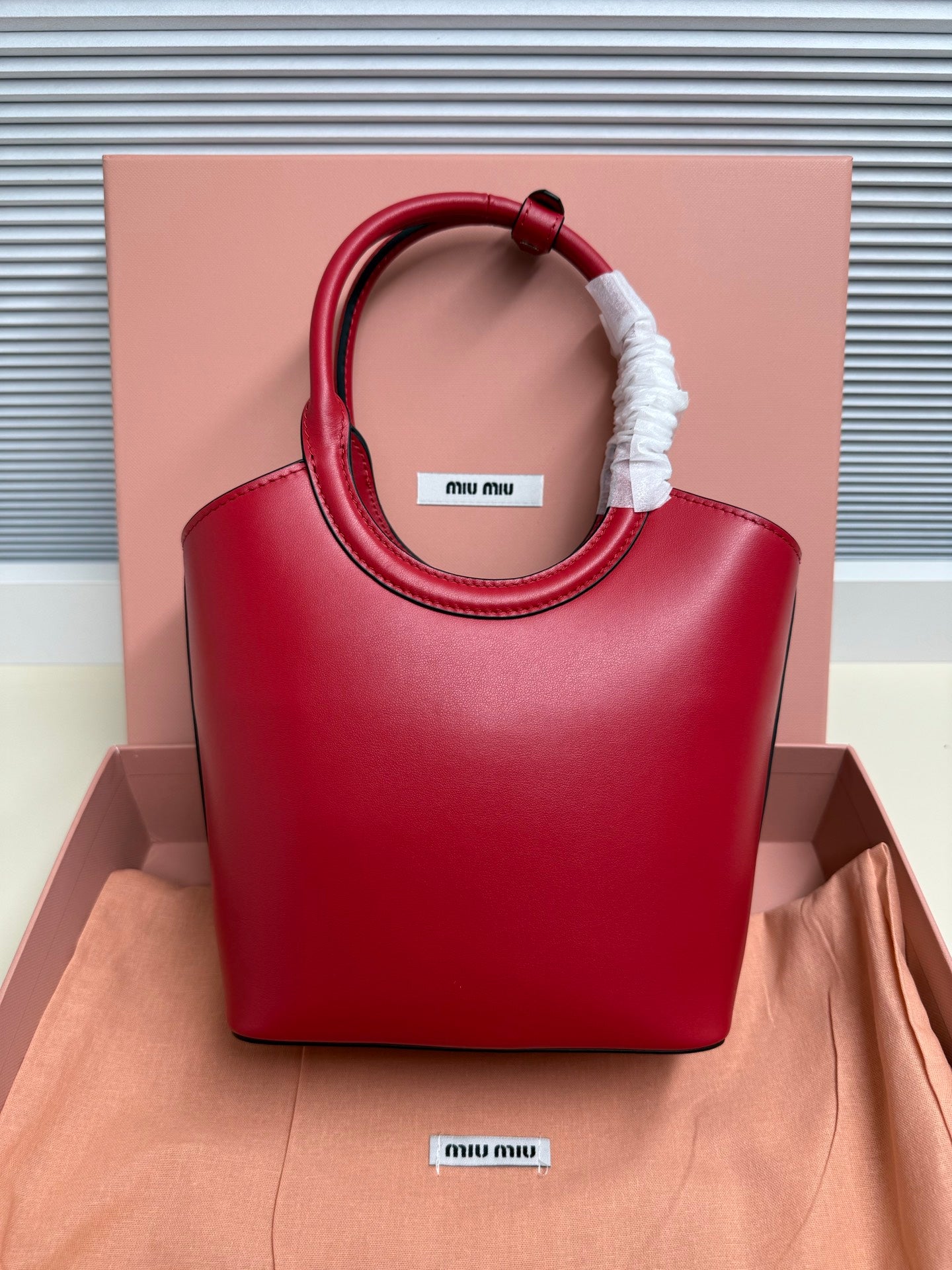 Red leather Miu Miu top-handle bag with circular handle and logo patch