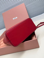 Red leather Miu Miu clutch-style bag with curved flap and stitched edge