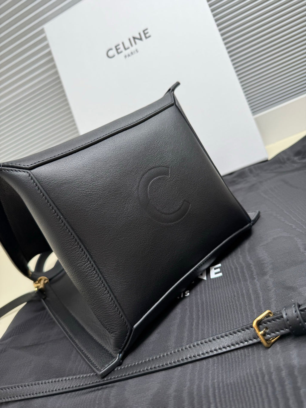 Celine dark leather clutch-style bag with embossed logo, top zipper and strap hardware