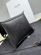Celine dark leather clutch-style bag with embossed logo, top zipper and strap hardware