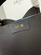 Celine dark leather handbag close-up of front logo patch and blue-lined interior opening