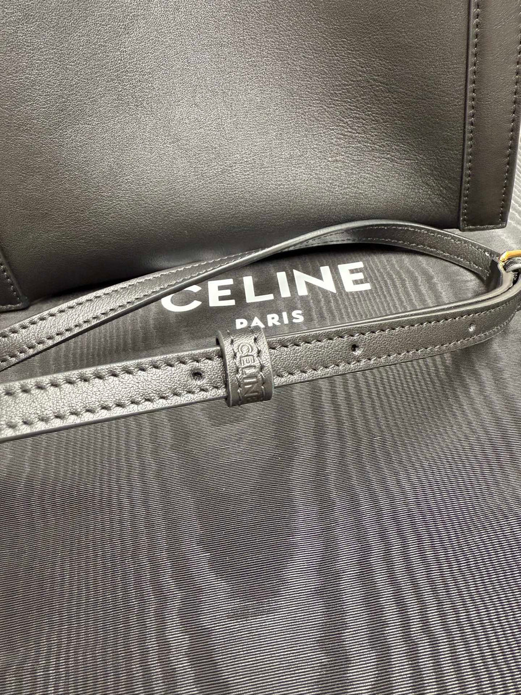 Celine dark leather handbag with striped canvas lining, front edge stitching and strap