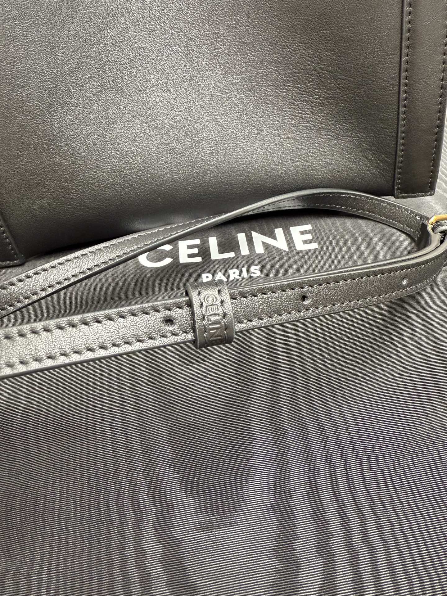 Celine dark leather handbag with striped canvas lining, front edge stitching and strap